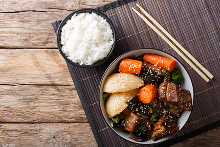 Korean stewed beef short ribs with vegetables and rice garnish close-up on the table. Horizontal top view from aboveの写真素材