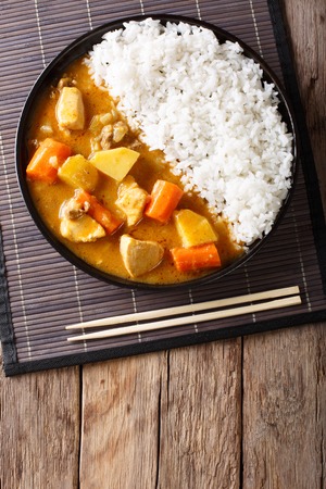 Japanese curry rice with meat, carrot and potato close-up on a plate on a table. Vertical top view from aboveの写真素材