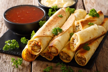 Tasty taquitos with chicken and two sauces close-up on the table. horizontalの写真素材