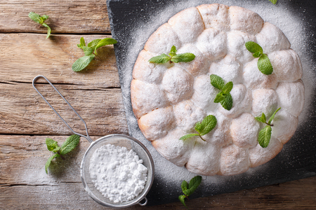 Freshly baked sweet yeast rolls decorated with mint and powdered sugar close-up on the table. horizontal top view from above
の写真素材