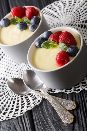 vanilla pudding decorated with raspberries and blueberries close-up on the table. vertical
の写真素材