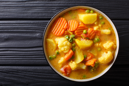 Vegetarian curry from vegetables with coconut milk close-up in a bowl on the table. horizontal top view from above
の写真素材