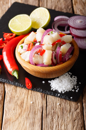 South American ceviche of fish cod with onions and peppers in a bowl close-up on the table. vertical
の写真素材