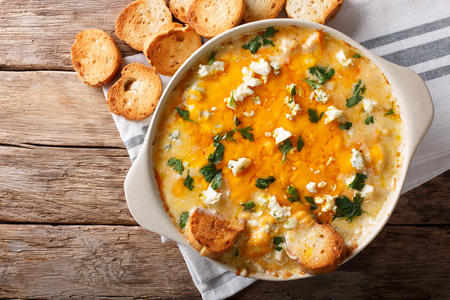 American food: hot chicken buffalo dip close-up in a baking dish with toasted bread on the table. Horizontal top view from above
の写真素材