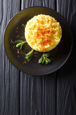 Delicious Italian risotto with saffron and mint (Risotto alla milanese) closeup on a plate. Vertical top view from above
の写真素材