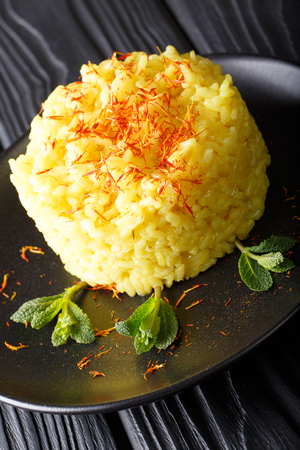 Italian risotto alla milanese with saffron closeup on a plate on a table. vertical
の写真素材