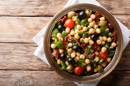 East balela salad with chickpeas, tomatoes, onions, olives and herbs closeup on a plate. horizontal top view from aboveの写真素材