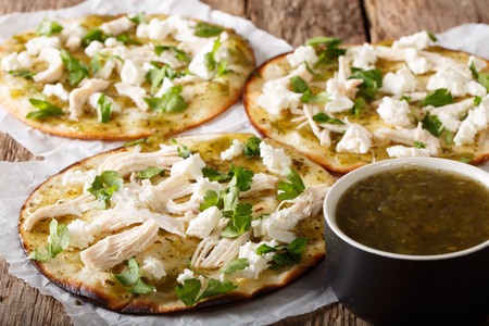 Delicious mexican chalupas with queso fresco and chicken meat and green sauce close-up on the table. horizontal
の写真素材