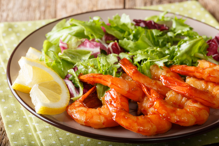 Delicious glazed shrimps with honey and soy sauce and fresh salad close-up on a plate on a table. horizontal
の写真素材