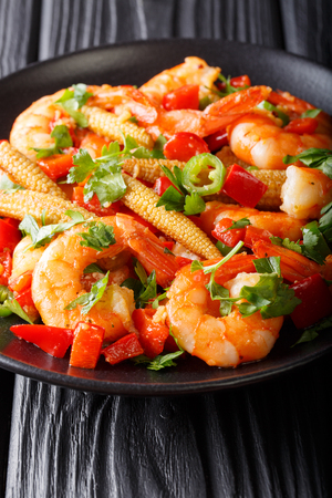 Portion of spicy shrimp with pepper, garlic, corn cob and herbs close-up on a plate. vertical
の写真素材