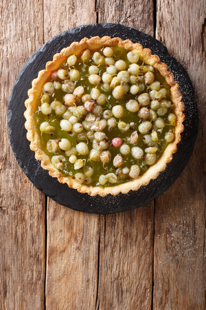 Delicious summer dessert: gooseberry tart on a close-up on a table. vertical top view from above, rustic
の写真素材