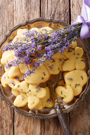 Homemade lavender shortbread cookie close-up on a plate on a table. Vertical top view from aboveの写真素材