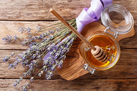 Healthy food: floral lavender honey in a glass jar close-up on a table. horizontal top view from aboveの写真素材