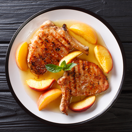 French recipe grilled spicy pork with peaches, honey garlic sauce and mint closeup on a plate. top view from aboveの写真素材
