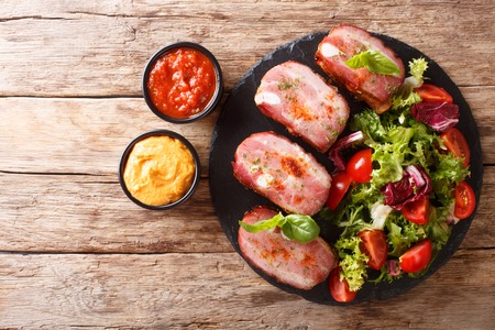 BBQ menu: Pork ribs and fresh vegetable salad on a slate plate with ketchup and mustard. horizontal top view from aboveの写真素材