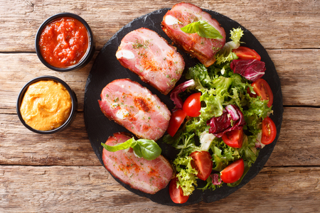 Grilled pork brisket and fresh salad are served ketchup and mustard on the table. horizontal top view from aboveの写真素材