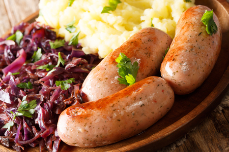 Delicious dinner of mashed potatoes, stewed red cabbage and sausages close-up on a plate. horizontalの写真素材