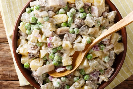 Latvian potato salad rasol with herring and beef close-up in a bowl on a table. horizontal top view from aboveの写真素材
