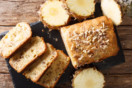 Delicious homemade pineapple bread with walnuts close-up on the table. Horizontal top view from...