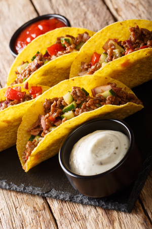 Mexican tacos stuffed with minced beef and vegetables close-up on the table. verticalの写真素材