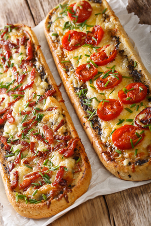 Delicious casserole sandwich with bacon, mushrooms, tomatoes and mozzarella cheese close-up on the table. verticalの写真素材