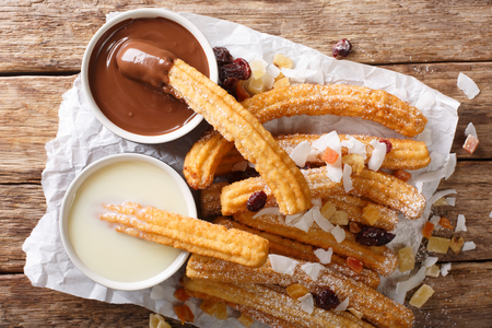 Spanish dessert churros served with hot chocolate and condensed milk close-up on the table. horizontal top view from aboveの写真素材