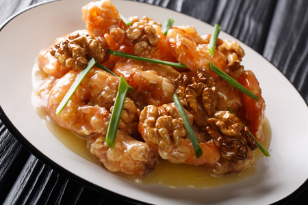 Honey Shrimp are fried with a tempura batter and quickly tossed in a honey sauce and sweetened walnuts close-up on a plate. horizontalの写真素材