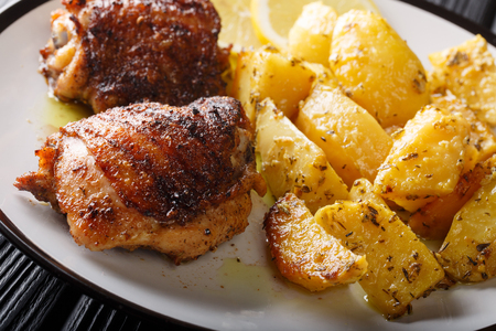 Greek food chicken thighs grilled with fried lemon garlic oregano potatoes closeup on a plate. horizontalの写真素材
