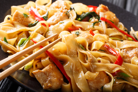 Drunken noodles pad kee mao with chicken, basil, chili pepper and sauce close-up on a plate on the table. horizontal
の写真素材