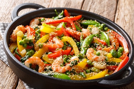 Vegetable stir fry with shrimps and sesame close-up in a frying pan on the table. horizontalの写真素材