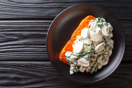 Baked Florentine salmon with creamy wine sauce, seasoned with roasted spinach and mushrooms closeup on a plate on the table. Horizontal top view from above
の写真素材