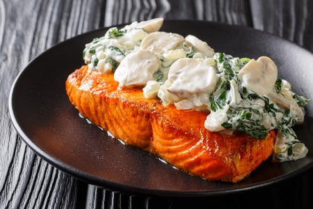 Baked Florentine salmon with creamy wine sauce, seasoned with roasted spinach and mushrooms closeup on a plate on the table. horizontal
の写真素材
