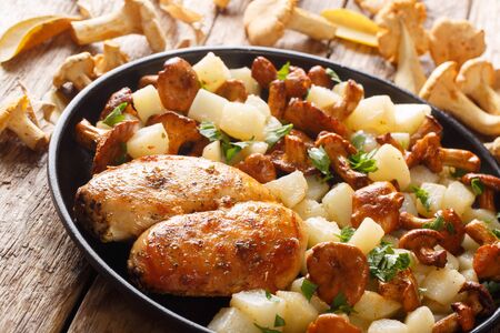 Boiled potatoes with chanterelles served with fried chicken breast close-up on a plate on the table.の写真素材