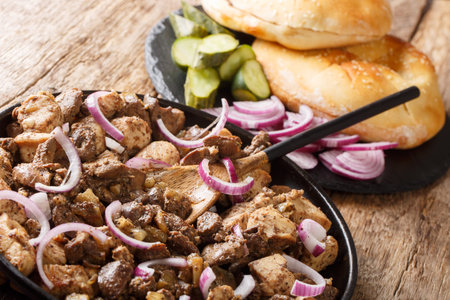 Tasty Jerusalem mixed grill or meorav Yerushalmi served with pita and pickles close-up on a plate on...