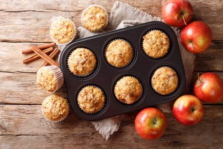 Tasty baked apple muffins with cinnamon close-up in a tray on the table. horizontal top view from aboveの写真素材