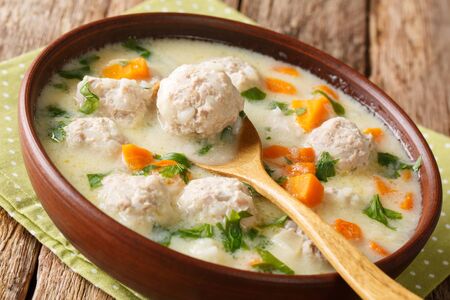 Homemade Bulgarian soup with meatballs and vegetables close-up in a bowl on the table.の写真素材