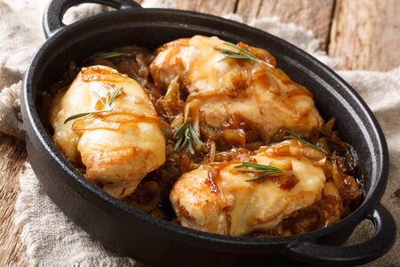 French chicken onion fillet cooked with gruyere cheese and spicy wine sauce close-up in a pan on the table. horizontalの写真素材