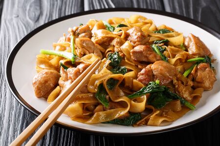 Fried rice noodles with chicken, Chinese broccoli and egg close-up on a plate on the table. horizontal
の写真素材