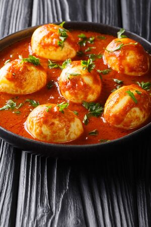 Boiled curry eggs in spicy sauce close-up in a plate on the table. vertical
の写真素材