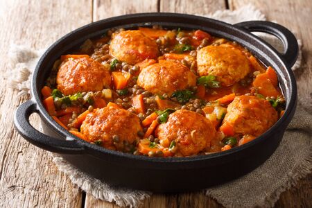 Spicy meatballs with lentil garnish in tomato sauce close-up in a pan on the table. horizontal
の写真素材