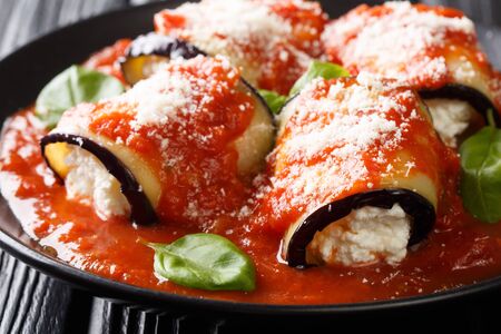 Baked eggplant roll with ricotta cheese in tomato sauce close-up in a plate on the table. horizontal
の写真素材