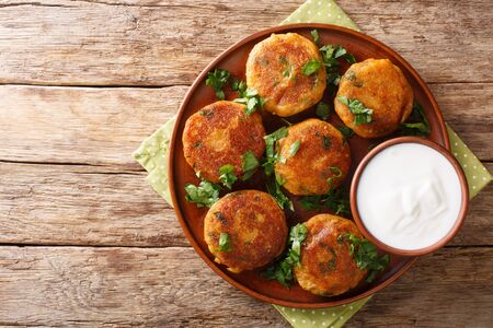Indian potato patties Aloo Tikki served with yogurt close up in a dish on the table. Horizontal top view from above
の写真素材
