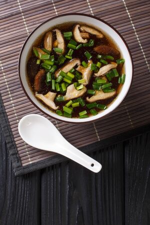 Vegetarian miso soup with shiitake mushrooms and green onions close-up in a bowl on the table. vertical top view from aboveの写真素材