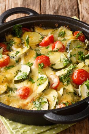 zucchini casserole with cheese and tomatoes close-up in a pan on the table. vertical
の写真素材