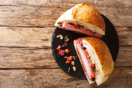 Muffaletta Sandwich with Homemade Bread and Olive Salad close-up on a slate board on the table horizontal top view from aboveの写真素材