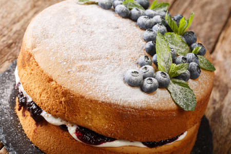 Victoria sponge cake recipe combines blueberry jam and cream closeup on the slate board on the table. Horizontalの写真素材