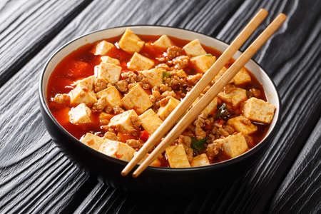 Mapo tofu is a famous Sichuan dish consisting of tofu, minced pork, hot sauce closeup in the plate on the table. Horizontalの写真素材