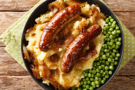 Irish Bangers and Mash is a dish consisting of sausages served with mashed potatoes and onion gravy closeup in the plate on the table. horizontal top view from aboveの写真素材