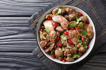 Homemade Kuchmachi made from chicken liver, hearts and gizzards with onions, walnuts and pomegranate close-up in a bowl on the table. horizontal top view from aboveの写真素材