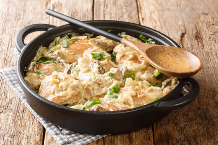 Delicious homemade chicken with mushrooms in wine Riesling with cream close-up in a pan on the table. horizontalの写真素材